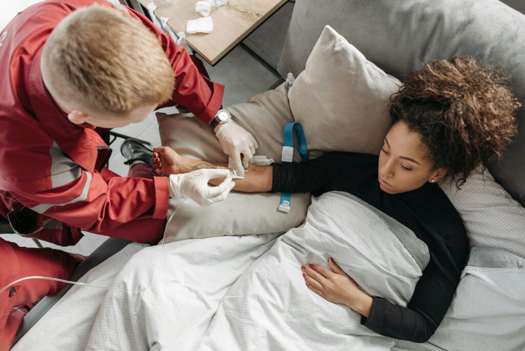 Paramedic tending to a woman at home, showcasing medical assistance in a personal setting.