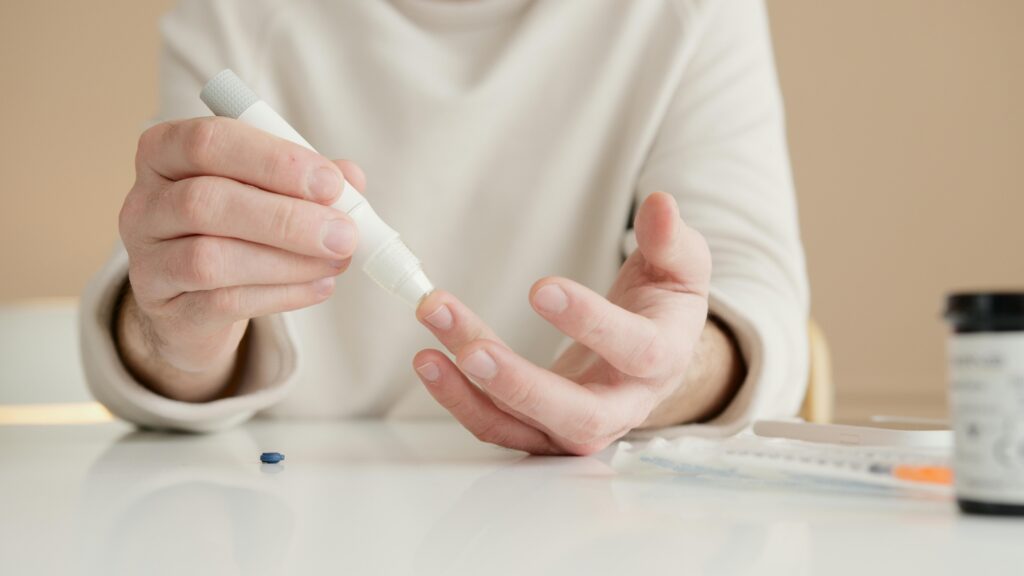 Close-up of a person using a glucometer to test blood sugar at home.