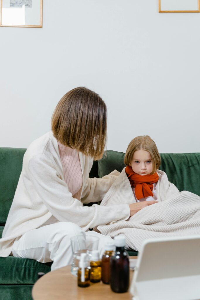 A woman comforts her sick child at home, illustrating care and family connection.