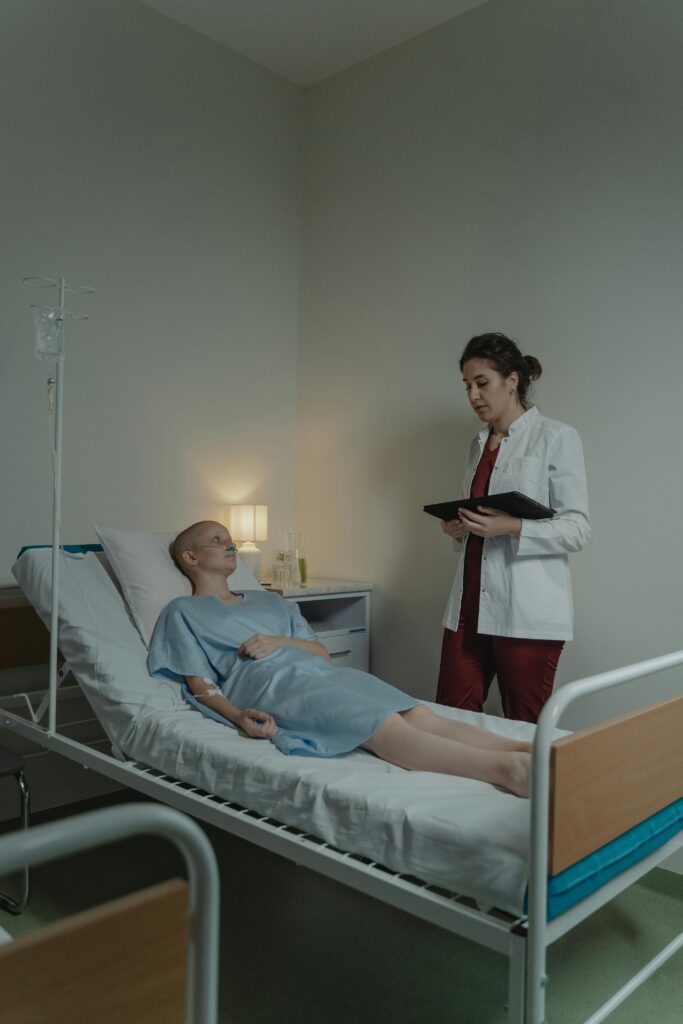 A doctor consults a female patient lying in a hospital bed, offering care and support.