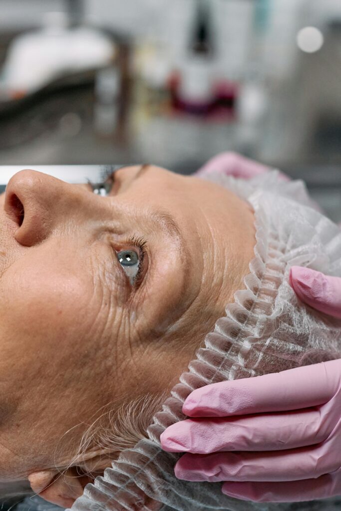 Close-up of a senior woman receiving a facial spa treatment indoors, promoting relaxation and skincare health.
